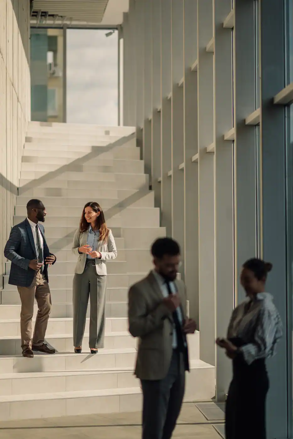 Business people talking on stairs in modern office building